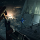In extreme dark, the player loads a single bullet into a long rifle, while a man falls off a nearby building into the snow. In the distance, a car's headlights cast light onto the backs of three people, walking through the storm.